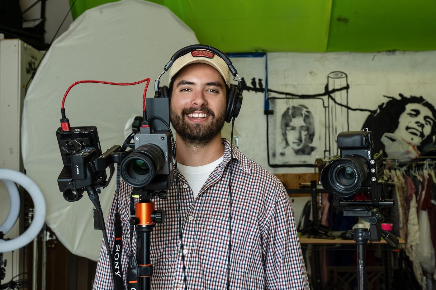Alex Whipple smiling in the Life Echo Media studio, surrounded by Sony cinema cameras